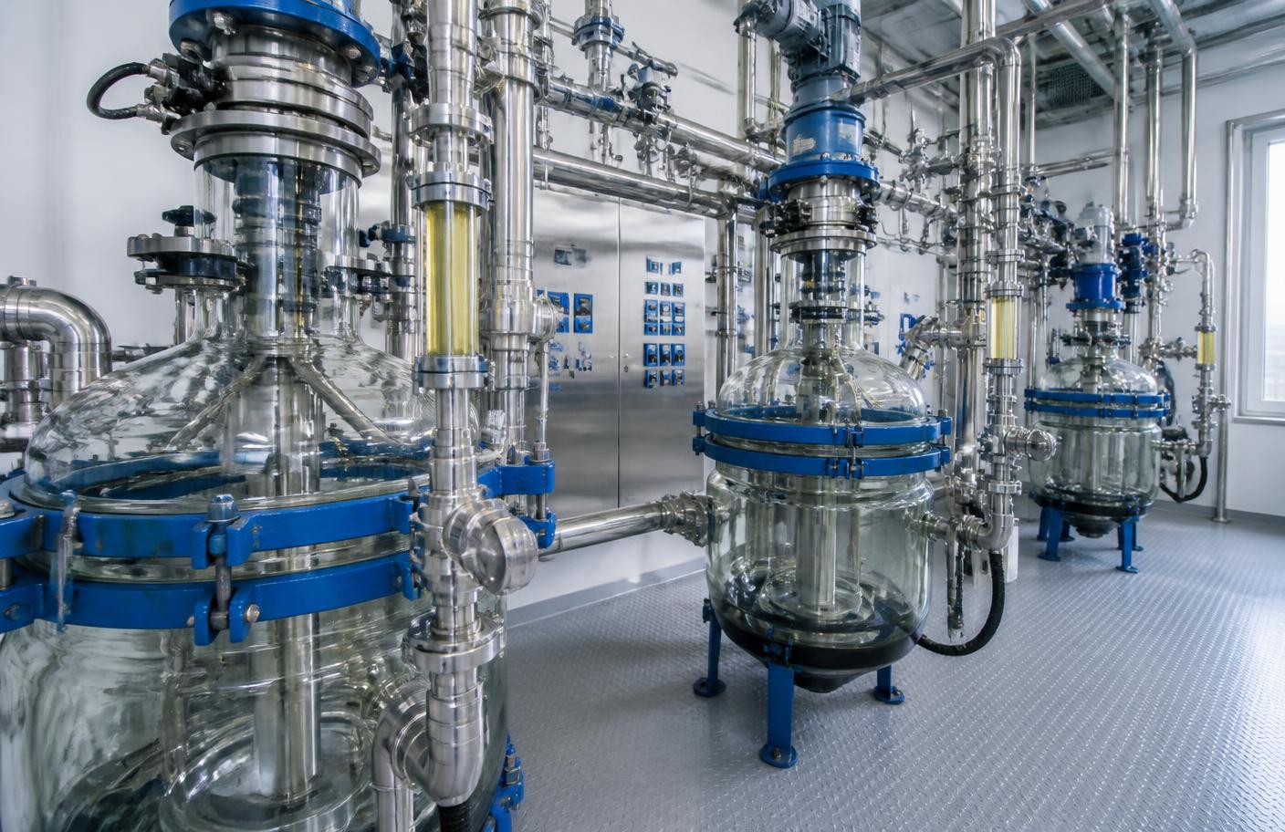 Chemical processing plant interior with glass-lined reactors and stainless steel piping
